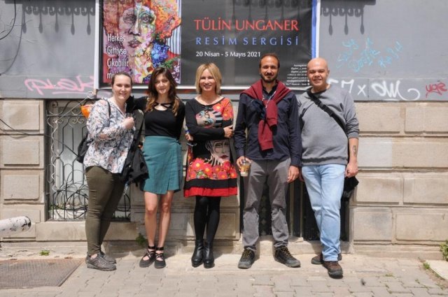 Tülin Unganer
Sanatçı çocukluğundan beri resim ve fotoğraf sanatı ile ilgilenmektedir. İlk olarak 1996 yılında İzmir’de ünlü ressam Feriha Turan’ın atölyesinde çalışmalarına başlamıştır. Yıllar içinde çeşitli atölyelerde farklı teknik çalışmaları yaptıktan sonra, 2017 yılında ressam Oğuz Demir ve Seçil Zenginler’in atölyesinde çalışmalarına farklı bir boyut kazandırmıştır. Sanatçı ayrıca IWAF (Uluslararası Kadın Sanatçılar Federasyonu) Türkiye temsilcisidir.Bugüne kadar yurtiçi ve yurt dışında 15 karma 1 kişisel sergide yer almıştır. Resimlerinde sürreal hikayeler anlatan Unganer’in karakterleri genellikle cinsiyetsizdir. Teknik olarak karışık medya kullanır. Özellikle eco-print tekniğini çok sık kullanır. (Doğadan topladığı bitkileri özel bir işlemden geçirerek elde ettiği kök boyalarla uyguladığı baskı tekniği ile elde ettiği kağıtları hemen her resminde arka planda uygular) Yakın dönem resimlerinde ahşap panel üzerine kolaj ve karışık teknikler uygulayarak yaptığı portrelerine epoksi ile farklı bir boyut kazandırdığı görülür. Sanatçı çalışmalarına İzmir’de yer alan kendi atölyesinde devam etmektedir.