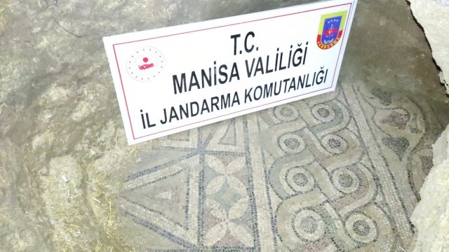 Mustafa Temiz -Manisa Son Haber- Manisa İl Jandarma Komutanlığı Kaçakçılık ve Organize Suçlarla Mücadele Şube Müdürlüğü, İstihbarat Şube Müdürlüğü ve Saruhanlı İlçe Jandarma Komutanlığı ekiplerince yapılan istihbari çalışmalar neticesinde Saruhanlı İlçesi Sarıçam Mahallesinde İkamet eden H.Ö. (Erkek 62 yaşında) ve M.Ö (Erkek 70 yaşında) isimli şahısların evinde / eklentilerinde tarihi eser olduğu, evin tabanının kazıldığı, tabanda mozaik olduğu ve bu mozaik parçanın pazarlanmaya çalıştığı tespit edilmiştir. Bunun üzerine Saruhanlı Sulh Ceza Hakimliğinden alınan arama kararına istinaden 14.12.2021 günü saat 14.00 ile 16.00 saatleri arasında bahse konu yerde yapılan aramada söz konusu şahısların ağıl olarak kullandığı kapalı yerin tabanında Roma dönemine ait olduğu değerlendirilen taban mozaiği, (3) adet çerçeve içerisinde Osmanlıca yazılı belge, Bizans dönemine ait olduğu değerlendirilen (1) adet tarihi küçük kazan, (1) adet kılıç, (2) adet kama, (2) adet barutluk, (2) adet metal sahin, (1) adet metal tabak, (2) adet metal yağdanlık, (1) adet kapı tokmağı, (1) adet sahin kapağı, (1) adet kapaklı ve kulplu bakraç, (3) adet kirkit, (1) adet pirinç kandil, (1) adet tarihi ütü, (2) adet halı makası, (1) adet kapaklı ve kollu kahve değirmeni, (2) adet boş kovan, (2) adet kazı küreği ele geçirilmiştir.