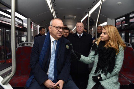 Manisa Büyükşehir Belediye Başkanı Cengiz Ergün, elektrikli otobüslerin şarj istasyonunda yaptığı ziyaret sonrasında Manisa’ya ulaşan 10 adet elektrikli otobüsü inceledi. Otobüslerden bir tanesinin direksiyonuna geçen Başkan Ergün, elektrikli otobüsleri yeni yılın ilk aylarında hizmete almayı hedeflediklerini kaydetti. 

Manisa Büyükşehir Belediyesi, ulaşımda dönüşüm projesi kapsamında toplu ulaşımda yapmış olduğu yeni proje ile Manisa trafiğinin çözümü konusuna katkı sağlamış aynı zamanda vatandaşların da toplu ulaşımda daha rahat ve konforlu bir ulaşım yapmaları için toplu ulaşım araçlarını yenilemişti. Manisa Büyükşehir Belediyesi kent içi trafik sorununun çözümüne katkı sağlaması için yeni yıl ile birlikte elektrikli otobüsleri hizmete almaya hazırlanıyor. Manisa Büyükşehir Belediye Başkanı Cengiz Ergün, Manisa’ya gelen 10 adet 18 metrelik elektrikli otobüsü, park halinde bulunduğu şarj istasyonunda inceledi. İnceleme sırasında Manisa Büyükşehir Belediyesi Genel Sekreter Yardımcısı Yılmaz Gençoğlu, Şoförler ve Otomobilciler Odası Başkanı Salih Karaağaç, daire başkanları hazır bulundu. 
Otobüsün Deneme Sürüşünü Gerçekleştirdi
Başkan Ergün, ilk olarak elektrikli otobüslerin bakım ve servislerinin yapılacağı şarj istasyonlarının ve idari bölümlerin bulunduğu binada incelemede bulundu. Yüklenici firma yetkilisinden bilgiler alan Başkan Ergün, sonrasında elektrikli otobüsleri inceledi. Otobüslerin dış görüntüsünü inceleyen Başkan Ergün otobüslerin içlerinde de yaptığı inceleme sonrasında elektrikli otobüsün direksiyonuna geçerek deneme sürüşü yaptı. Otobüsün direksiyonuna geçen Başkan Ergün, araçlardan gayet memnun kaldığını belirterek, vatandaşların otobüslerde cep telefonlarını şarj edebileceklerini belirterek, Ulaşım Dairesi’nin kablosuz internet (wifi) kullanabilmeleri için çalışma yürüttüklerini söyledi. 
“Ocak sonu Şubat başı hizmette olması hedefleniyor”
Başkan Ergün, inceleme ve deneme sürüşü sonrasında yaptığı açıklamada, ilk olarak 10 adet 18 metrelik otobüsün Manisa’ya geldiğini belirterek, “İki gün öncesi bununla ilgili Yol Yapım ve Onarım Daire Başkanlığı, Ulaşım Daire Başkanlığı ve MANULAŞ bünyesinde toplantımızı yapmıştık. Önümüzdeki bir iki hafta daha bu toplantılar devam edecek. Mevcut hem servis güzergahlarının hem yolların ana arterde çalışacak olan bu elektrikli otobüslerimizin tercihli yolları çalışmasıyla ilgili hazırlıklar son noktaya geldi. Tahmin ediyorum Ocak sonu Şubat başı gibi bu araçlarımızı Manisa’da inşallah hizmete sokmayı hedefliyoruz. Şimdiden hayırlı olsun diyorum” dedi. 
“Toplu ulaşım araçlarını özendirmemiz lazım” 
Manisa’nın araç sayısı ve trafik yoğunluğu açısından önde gelen iller arasında yer aldığının altını çizen Başkan Ergün, “Burada amaç bu tür araçların hizmet vermesi için sahaya sürdüğümüzde, vatandaşlarımızın artık özel araçların kullanmak değil, ulaşım için toplu taşıma araçlarını kullanmalarını özendirmemiz lazım. Şehir içindeki trafiğin daha aza inebilmesi için toplu ulaşımın Manisa’da kullanım oranı yüzde 8. Vatandaşlarımızın gideceği yere özel arabalarıyla gidiyor, sonrasında park sorunu yaşıyor. Bugün binlerce sanayi esnafımız özel araçlarıyla işlerine gidiyorlar arabasıyla geliyorlar. Sabah ve akşam pik saatler dediğimiz, otobüslerin organize sanayi bölgesine işçi kardeşlerimizi işlerine götürmek için çalıştığı o saatlerde şehrin ana arterlerinde bilhassa Doğu Caddesi ve Karaköy hattı dediğimiz Dış Mahalle hattında bu araçlar muazzam bir kilitlenmeye sebep oluyor. Trafik açısından getirdiğimiz yeni önlemler, tercihli tek yönlü uygulamalar ile bu otobüslerin devreye girmesiyle inşallah o ana arterlerimizde trafik en aza inecek diye hesabını yapıyoruz. Bunları yaşayarak, uygulayarak, yerindeki eksiklikleri, hataları görerek daha iyi noktaya gelecek diye düşünüyoruz. Sadece Manisa’nın değil 81 ilin, 30 büyükşehirde en büyük dert yeni otopark alanlarının yaratılabilmesi, mevcut araçların park yerlerinin çoğaltılabilmesi. Bunlarla ilgili olarak geçmişten bugüne kadar belli imkanlar dahilinde park yeri sorunun çözülmesi için iyileştirme ve ilavelerimizi yapmıştık. Emniyetten alınan verilere göre Türkiye’de en fazla araç satın alınan, trafiğe çıkan, tescili yapılan iller arasında Manisa yer alıyor. Kişi başına düşen araç sayısı, şehir içinde kullanılan araç sayısı açısından bakıldığı zaman bunu önleyemiyorsunuz. Hayat devam ediyor. O açıdan kısmen de olsa o iyileştirmeler önümüzdeki süreç içinde de gelecektir ama çözülür mü tam anlamıyla çözülemez” diye konuştu. 
“Yeni güzergah ve otobüsler ile ulaşım süresi yarıya inecek” 
Toplu ulaşım araçlarını kullanan vatandaşların gidecekleri yere gitmeleri için ortalama 45 dakikalık bir zaman geçirdiğine dikkati çeken Başkan Ergün, “En önemli faktörlerden bir tanesi bir hata bindiğiniz zaman gideceğiniz yere 45-50 dakikada gidiyorsunuz. Biz yeni yaptığımız bu uygulamalarla bu süreyi yarı yarıya indiriyoruz. Sonuçta trafiğin akışı, 155 nolu otobüslerin ve elektrikli otobüslerin o tercihli yolu kullanmaları, hatlardaki yeni düzenlemeler bu gidiş geliş sürelerini yarı yarıya düşürüyoruz. İnsanlarımız tabi ki bu araçları bugüne kadar neden bu kadar az kullanıyor, uzun süre gideceği yere uzan dolanarak gideceği yere gitmekten vazgeçerek araç kullanımını bir yerde tercih ediyor. Bu süreleri biz aşağıya çektiğimiz zaman insanlarımız toplu ulaşım araçlarını daha fazla kullanacaktır diye düşünüyoruz” dedi.